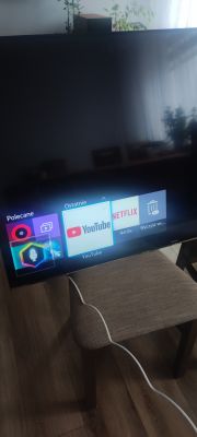 Telewizor z aplikacjami na ekranie i cienkimi pionowymi liniami.
