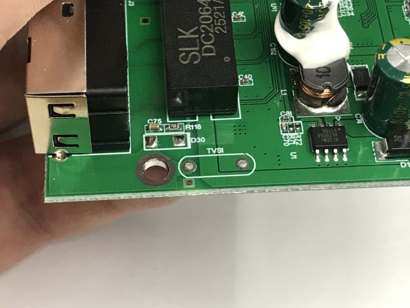 Close-up of a PoE switch PCB by an RJ45 port, showing TVS1 and D30 pads and a DC2064DG-marked chip