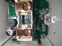 Close-up view of a circuit board with electronic components and brass connectors.