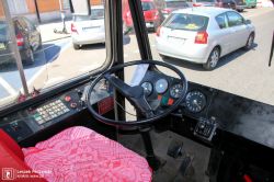Kabina kierowcy autobusu z widoczną deską rozdzielczą i pedałami.