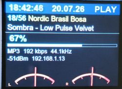 LCD screen showing audio player UI: time, date, “PLAY”, track info, 67% volume, and L/R meters