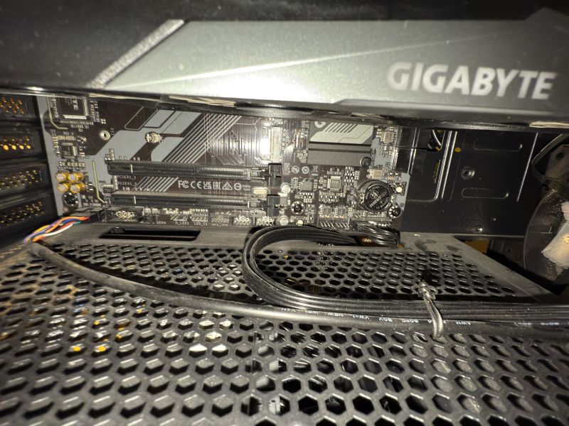 Zbliżenie na dolną część płyty głównej Gigabyte B760 z widocznymi złączami LED