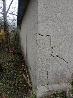 Ściana garażu z widocznymi pęknięciami na zewnętrznej powierzchni.