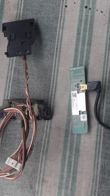 Podzespoły telewizora Panasonic TX 50 DS630 E na szarej tkaninie.