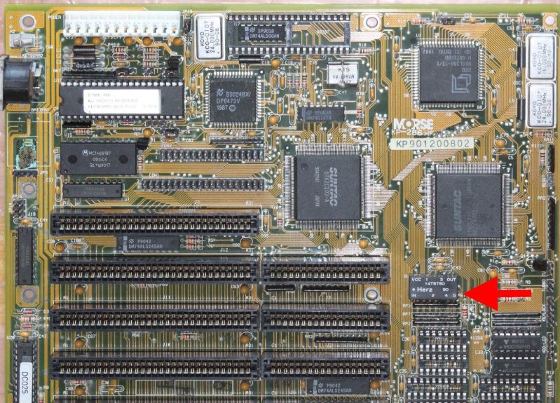 Close-up of 1980s computer motherboard with ISA slots and marked components