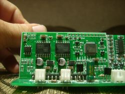 Zdjęcie dwóch modułów elektronicznych przylutowanych na płytce drukowanej, trzymanej ręką.