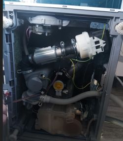 Wnętrze zmywarki Beko DIN28320 z widoczną pompą myjącą i podłączonymi przewodami