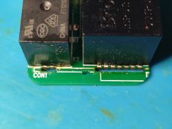 Close-up of damaged relay on PCB labeled CON1