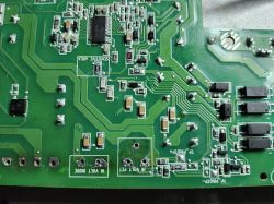 Green PCB with Electronic Components Close-up of a green PCB with visible traces and surface-mounted electronic components.