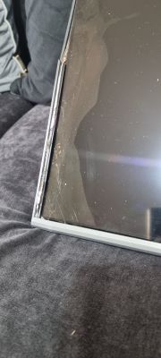 Pęknięty dolny róg ekranu telewizora z uszkodzoną ramką