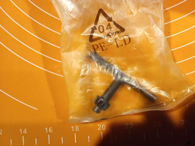 Klucz do futerka w plastikowym opakowaniu leży na pomarańczowej, oznakowanej powierzchni.