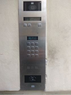 Panel domofonu z kamerą i klawiaturą numeryczną.