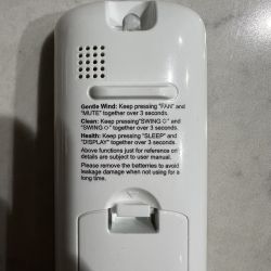 Backside of a remote control with printed English instructions on a white casing.