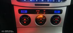 Panel sterowania klimatyzacją samochodową z wyświetlaczem cyfrowym i przyciskami.