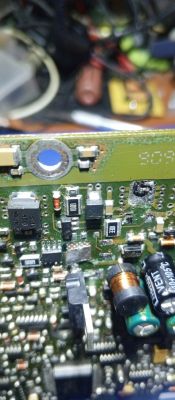Zbliżenie na płytkę drukowaną z elementami elektronicznymi, w tym kondensatory, cewki, i rezystory.