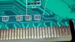 Zbliżenie PCB przy złączu PCIe, pola po elementach SMD zaznaczone pomarańczowymi ramkami