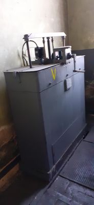 Wolnostojąca skrzynia z metalowymi elementami na górze, we wnętrzu pomieszczenia o surowych ścianach.