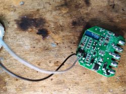 QS-WIFI-S03 Circuit Board with Connections QS-WIFI-S03 relay circuit board with connected wires on a wooden background.