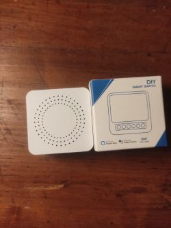 DIY smart switch device and its box on a wooden table.