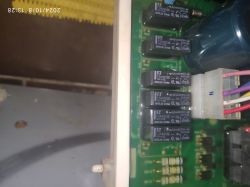 Zbliżenie na płyte elektroniczną z przekaźnikami i kolorowymi przewodami.