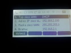 Ekran telefonu wyświetlający ustawienia sieci WAN, w tym typ sieci DHCP, adres IP, maskę sieci i bramę.