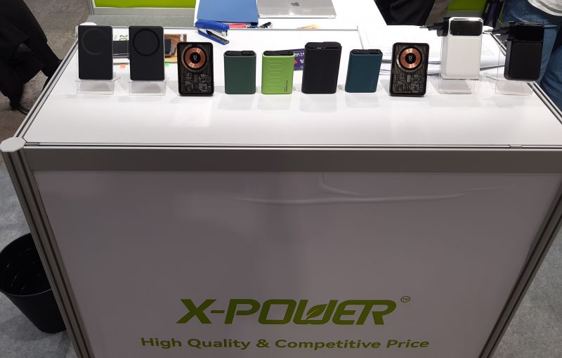 Stoisko firmy X-Power z różnorodnymi powerbankami na białym tle.
