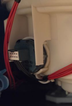 Zbliżenie na komponent elektroniczny z czerwonymi przewodami w obudowie z tworzywa.