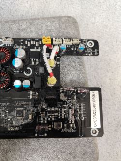 Zdjęcie płytki drukowanej z kondensatorami i rezystorami w urządzeniu elektronicznym.