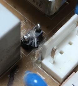 Zbliżenie na przypalony element elektroniczny obok złącza na płytce PCB