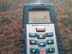 Elektroniczny dalmierz laserowy Bosch DLE 70 na blacie.
