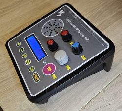 Nowoczesny metronom w czarnej obudowie z wyświetlaczem LCD i kolorowymi pokrętłami kontrolnymi na panelu frontowym.