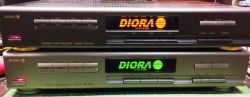 Two Diora stereo tuners with illuminated LCD displays and rows of buttons.