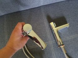 Chromowane baterie łazienkowe Hansgrohe na tle materiału obiciowego