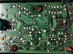 Zbliżenie na płytkę drukowaną z układem scalonym i lutowanymi połączeniami.
