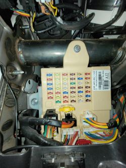 Widok na skrzynkę bezpieczników oraz przewody w samochodzie.