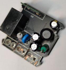 Printed circuit board with electronic components, including capacitors and resistors.
