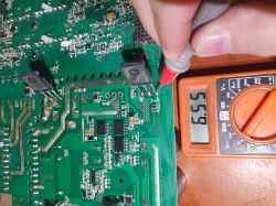 Printed circuit board with a multimeter showing a reading of 6.55 V.