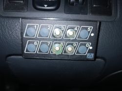 Zniszczona klawiatura numeryczna do samochodu z brakującymi przyciskami.