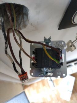 Włączenie przełącznika elektrycznego z przewodami widocznymi w ścianie.