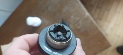 Zbliżenie na termostatyczną głowicę grzejnika z widocznym mechanizmem mocowania.