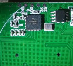 PCB Fragment with Integrated Circuits Close-up of a green printed circuit board with visible integrated circuits and electronic components.