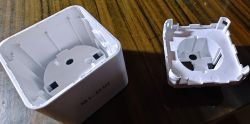 Photo of a white plastic device casing disassembled into parts.