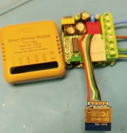 Smart Dimmer Module controller with a connected ESP-02S Wi-Fi module and removed yellow case on a blue background.