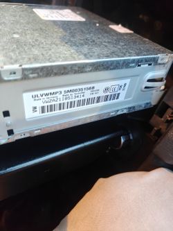 Naklejka z numerami na metalowej obudowie radia samochodowego Volkswagen, widoczny kod kreskowy.