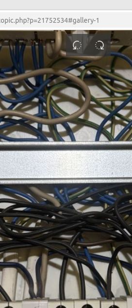 Nieuporządkowane przewody elektryczne w rozdzielnicy, widoczne różne kolory kabli.