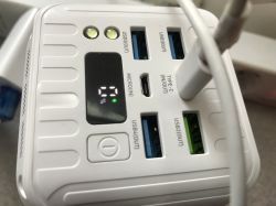 Zbliżenie na biały powerbank z wyświetlaczem LCD i pięcioma portami USB