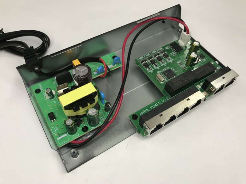 Inside a PoE switch: metal case with two PCBs, including RJ45 ports and a power-supply module