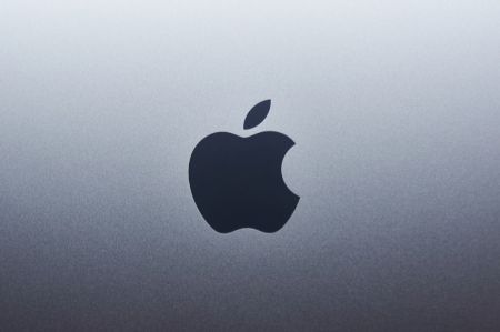 Czarne logo Apple na szarej, metalicznej powierzchni