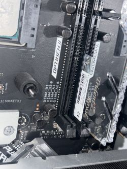 Zbliżenie na płytę główną z dwoma gniazdami RAM DDR4 i widocznymi kondensatorami obok