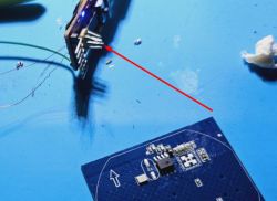 Close-up of a circuit board with soldering wires and an electronic module.